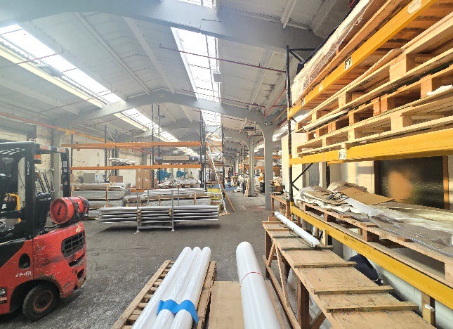 Interior of large-span industrial warehouse with forklift and racking